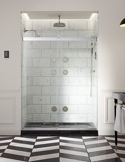 Marble shower with Kohler faucet and geometric floor patterns