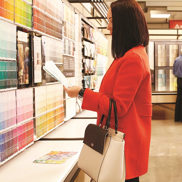 Des clients d’un magasin Benjamin Moore regardent des échantillons de couleurs et d’autres outils de sélection de la couleur.