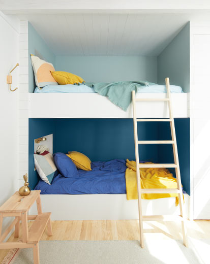 Des lits superposés dans une alcôve aux murs en deux teintes de bleu