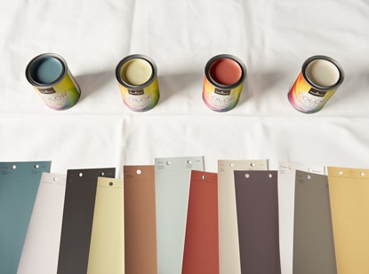 Open cans of paint colour samples and an array of colour swatches.