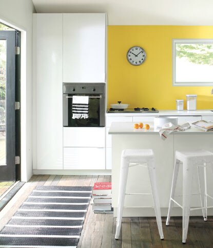 Trendy kitchen with yellow wall and industrial chairs