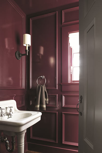 Les murs de la salle de bains sont enduits d’un violet foncé au fini très lustré.