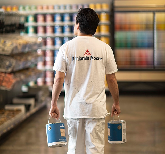 Un entrepreneur en peinture transporte des pots de peinture de qualité supérieure chez un détaillant indépendant Benjamin MooreMD.