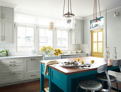 Une cuisine lumineuse et spacieuse avec un îlot attrayant de couleur Bleu d’Auvergne 2055-30.