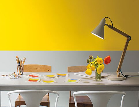 Bright yellow and gray dining room with wood and metal furniture.