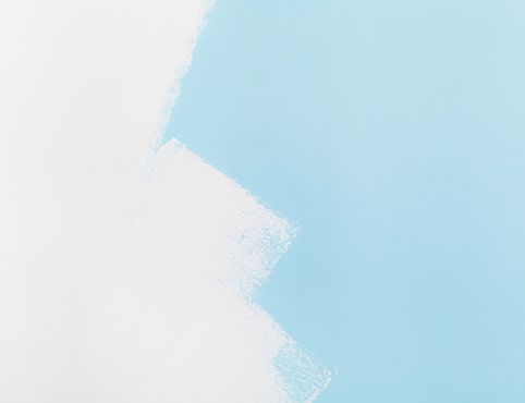 A blue wall in the process of being painted white.