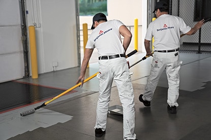 Painting contractors applying Corotech® COMMAND on a warehouse floor.