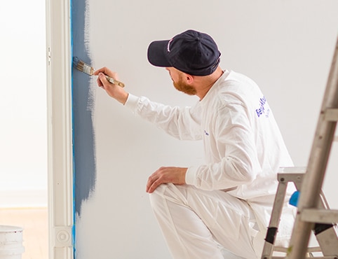 A Benjamin Moore painting contractor paints a wall